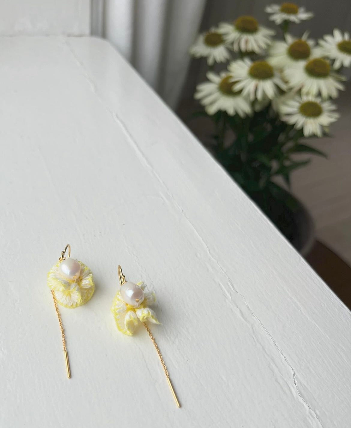 Flower-inspired earrings with freshwater pearls and yellow 'leaves'