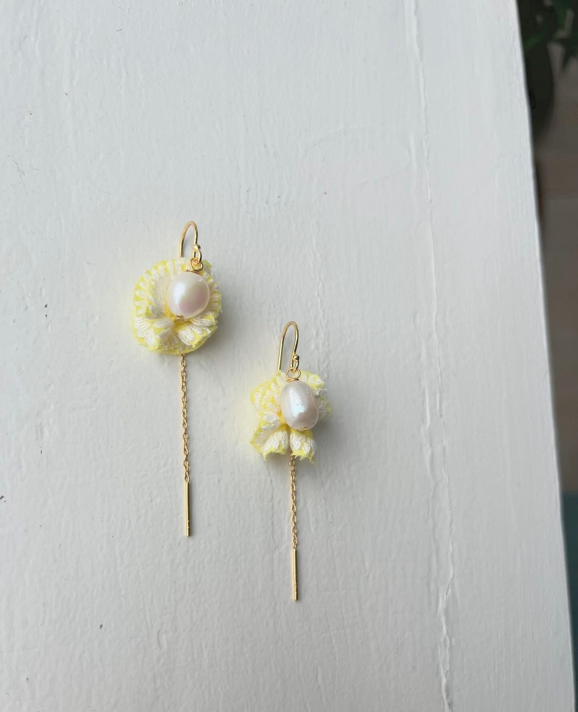 Flower-inspired earrings with freshwater pearls and yellow 'leaves'